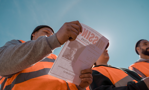 A construction worker viewing a missing person flier.